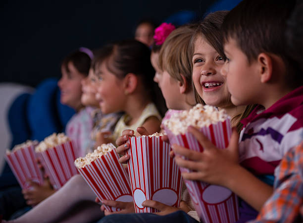 Kinderen kijken met popcorn naar de film